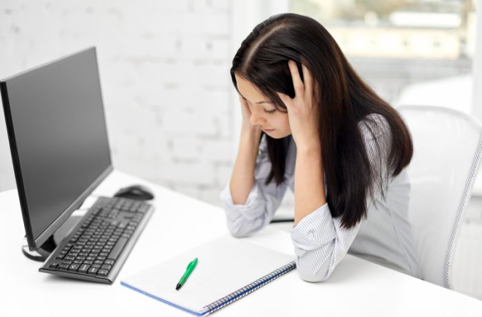 stressad affarskvinna som jobbar pa sin dator